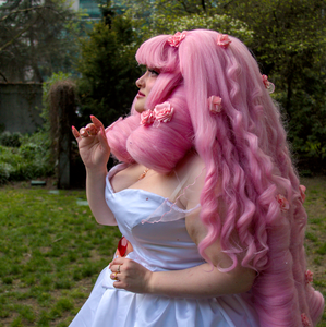 A cosplayer dressed as Rose Quartz from Steven Universe with a huge pink wig.